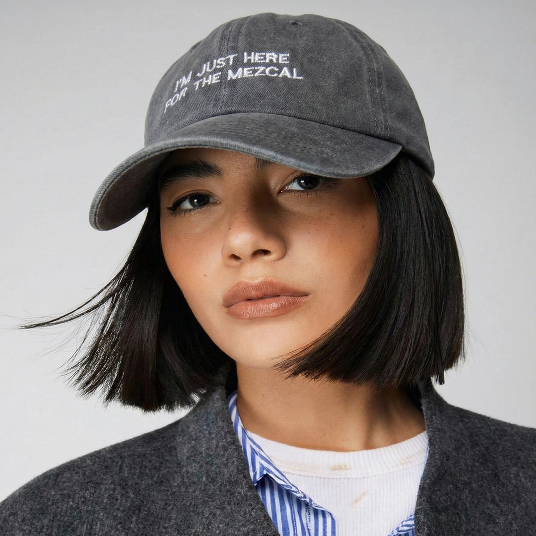 Model wearing the grey embroidered "I'm Just Here for the Mezcal" cap by Mezcal Mitre.