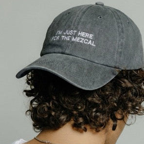 Model wearing the grey embroidered "I'm Just Here for the Mezcal" cap by Mezcal Mitre.